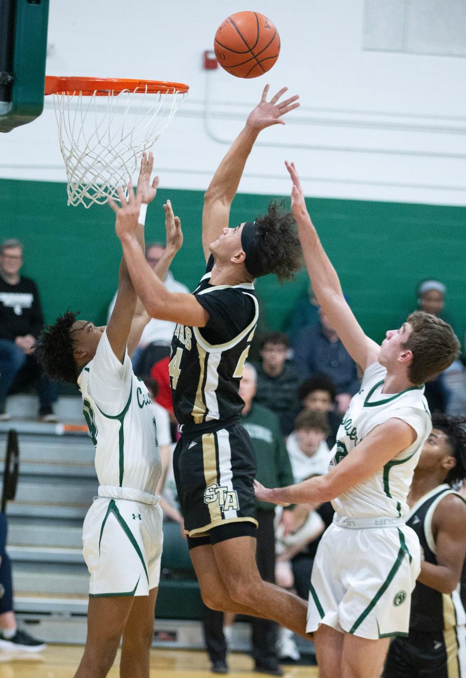 St Thomas Aquinas' Julius Kimbrough shoots a layup over Central Catholic's Amar Coney, left, and Dylan Rouse in the first half, Saturday, Jan. 28, 2023.