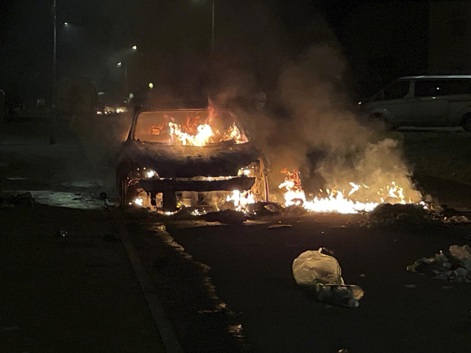 A car burns after being set on fire, on Highmead Road, Ely, in Cardiff, after a crash following a serious road traffic collision on Snowden Road in Ely in Cardiff, Tuesday, May 23, 2023. A few cars were set ablaze and objects were hurled at police after a traffic accident Monday night in the Welsh capital Cardiff grew into what officials described as “large scale disorder.” (Bronwen Weatherby/PA via AP)