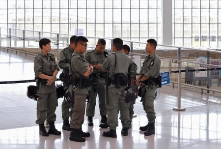 Riot police stand inside Hong Kong International Airport in Hong Kong, China