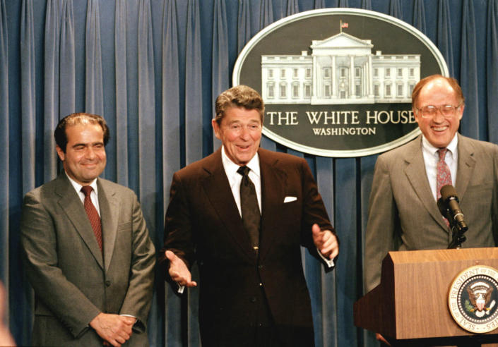 <p>President Ronald Reagan, center, gestures during a news conference at the White House June 17, 1986 , where he announced the nomination of Antonin Scalia, left, to the Supreme Court. Chief Justice William Rehnquist is at right. <i>(Photo: Ron Edmonds/AP)</i></p>