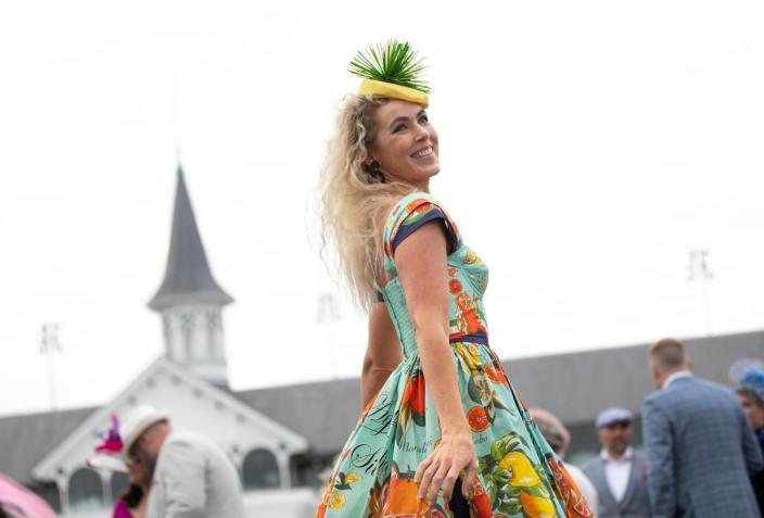 Qwynne Winslow, from Florida, wears a bright citrus-themed dress to her first Kentucky Derby in Louisville, Ky., Saturday, May 6, 2023.  She bought her fan from a shop in the hotel lobby.  Amy Wallot