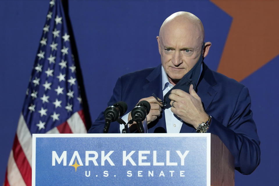 Mark Kelly, Arizona Democratic candidate for U.S. Senate, removes his mask as he prepares to speak at an election night event Tuesday, Nov. 3, 2020 in Tucson, Ariz. (AP Photo/Ross D. Franklin)