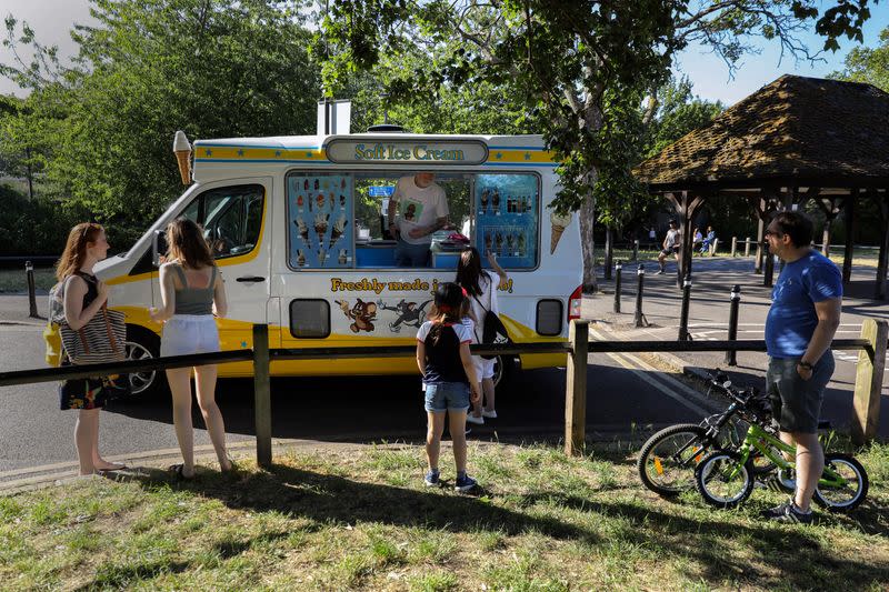 People queue at a traditional ice cream van at a Fulham park