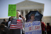 David Hayes, from Washington, left, and Maureen Murphy from Madison, Miss., who oppose the health care reform law signed by President Barack Obama, rally in front of the Supreme Court.