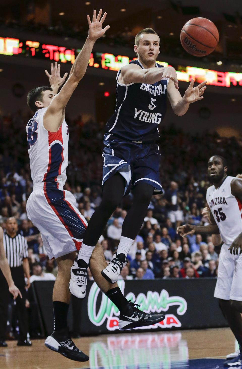 BYU's Kyle Collinsworth (5) passes off the ball against Gonzaga's Drew Barham, left, during the second half of an NCAA college basketball game for the West Coast Conference men's tournament title, March 11, 2014, in Las Vegas. Gonzaga won 75-64. (AP Photo/Julie Jacobson)