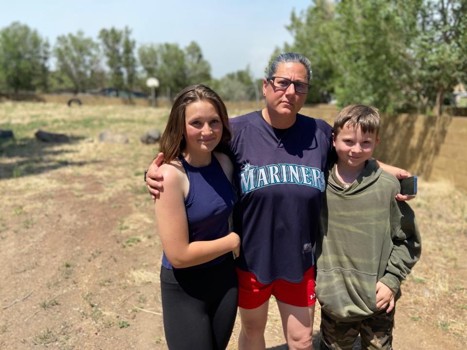 Addyson Cooper, 14, left, poses for a portrait with her mom, Tracy, center, and brother Justin, right, at Silver Saddle Mobile Home Park in Flagstaff on Tuesday, June 14, 2022. As of Tuesday afternoon, she had just returned home after an evacuation during the Pipeline Fire. A few weeks ago, her dad's house burned down in the Tunnel Fire, and Addyson lost many treasured possessions.