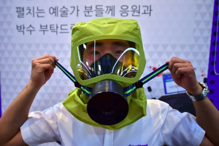 A South Korean resident puts on a gas mask during a civil defence drill against possible attacks by the North, in Seoul, on August 24, 2016