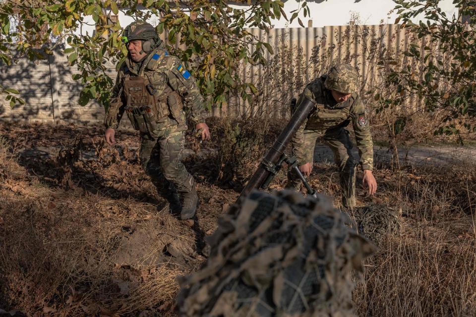 Ukrainian servicemen of the 123rd Territorial Defense Brigade in action while firing a mortar over the Dnipro River toward Russian positions (AFP via Getty Images)