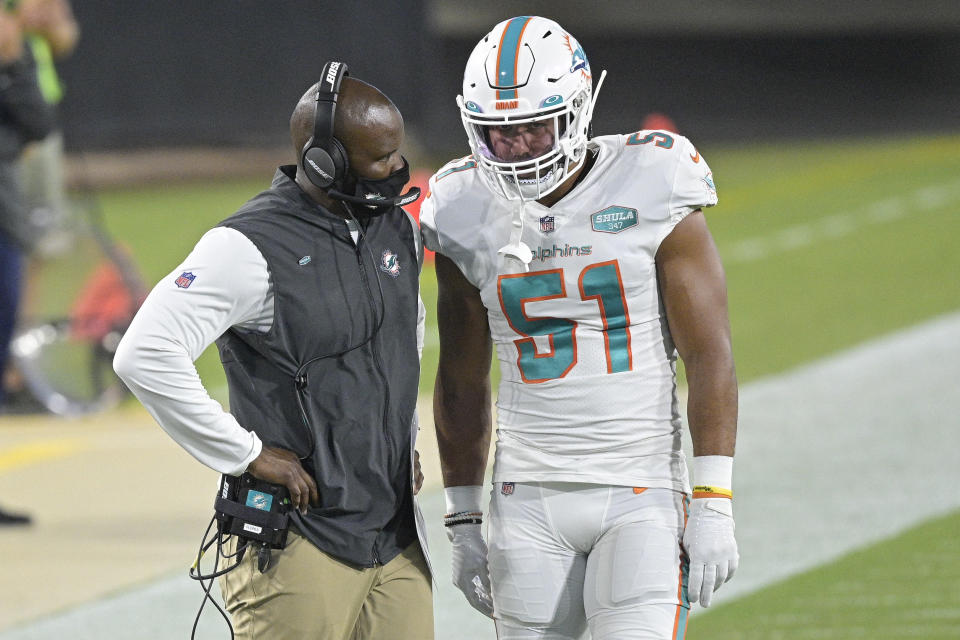 Miami Dolphins head coach Brian Flores, left, talks with outside linebacker Kamu Grugier-Hill (51) on the sidelines during the first half of an NFL football game against the Jacksonville Jaguars, Thursday, Sept. 24, 2020, in Jacksonville, Fla. (AP Photo/Phelan M. Ebenhack)