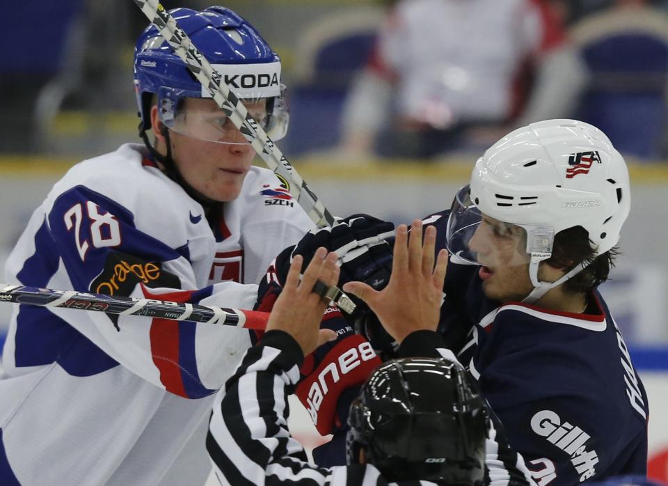 A linesman tries to break up the fight between Slovakia's Pavol Skalicky (L) and Ryan Hartman of the U.S during the second period of their IIHF World Junior Championship ice hockey game in Malmo, Sweden, December 28, 2013. REUTERS/Alexander Demianchuk (SWEDEN - Tags: SPORT ICE HOCKEY)