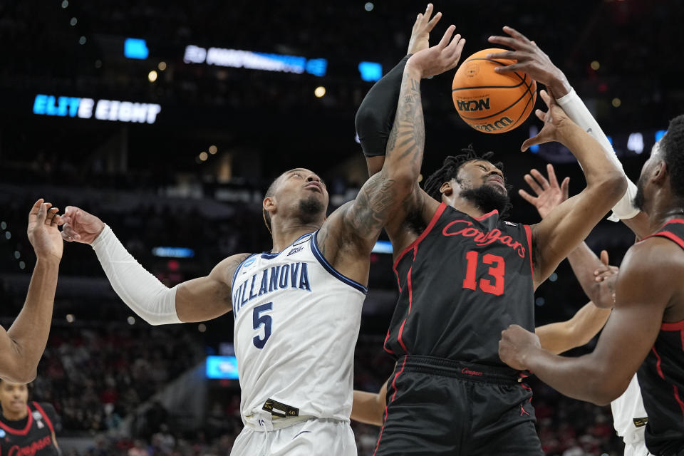 Villanova guard Justin Moore, left, vies for the ball with Houston forward J'Wan Roberts during the first half of a college basketball game in the Elite Eight round of the NCAA tournament on Saturday, March 26, 2022, in San Antonio. (AP Photo/David J. Phillip)