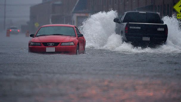 PHOTO: In this July 4, 2014, file photo, a pick-up truck makes its way pass an abandoned car in New Bedford, Mass., which were flooded by the heavy rains brought in by Hurricane Arthur. (Boston Globe via Getty Images, FILE)