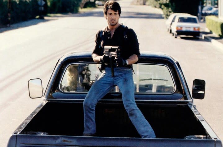 A man holds a gun on a truck in Cobra.