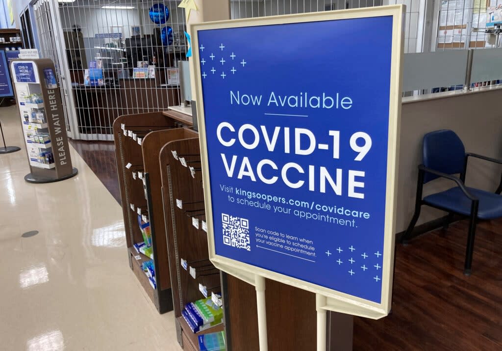 In this Saturday, Oct. 23, 2021, photograph, a sign notifies customers that COVID-19 vaccinations are available at a pharmacy in a grocery store in Monument, Colo. Millions of U.S. workers now have a Jan. 4 deadline to get a COVID vaccine. (AP Photo/David Zalubowski)