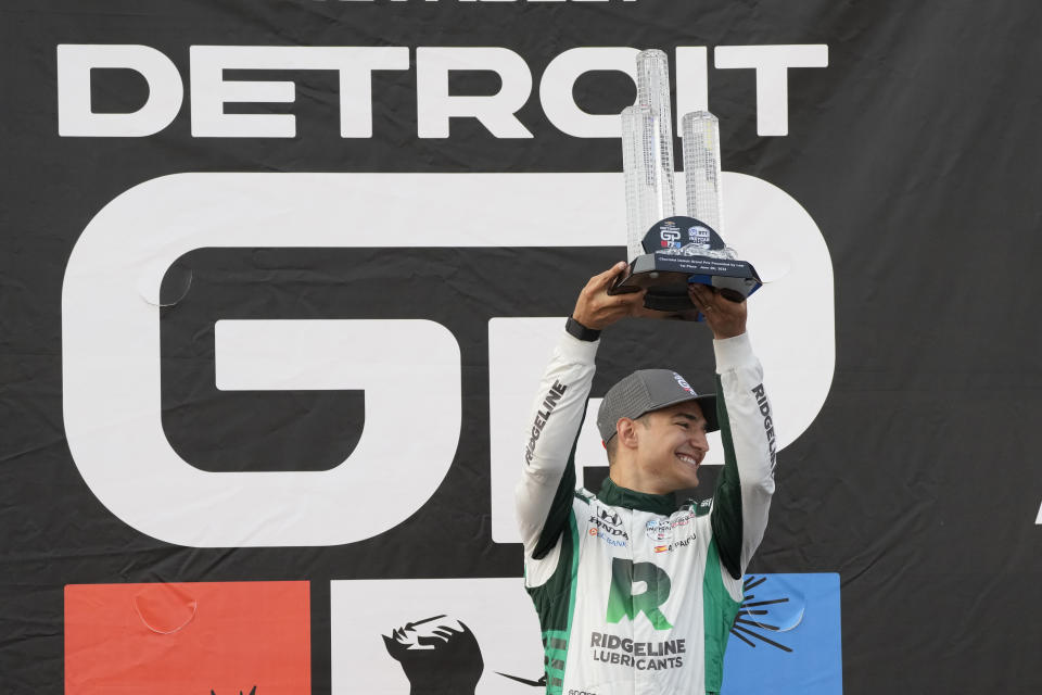 Alex Palou raises the winner's trophy after the IndyCar Detroit Grand Prix auto race, Sunday, June 4, 2023, in Detroit. (AP Photo/Carlos Osorio)