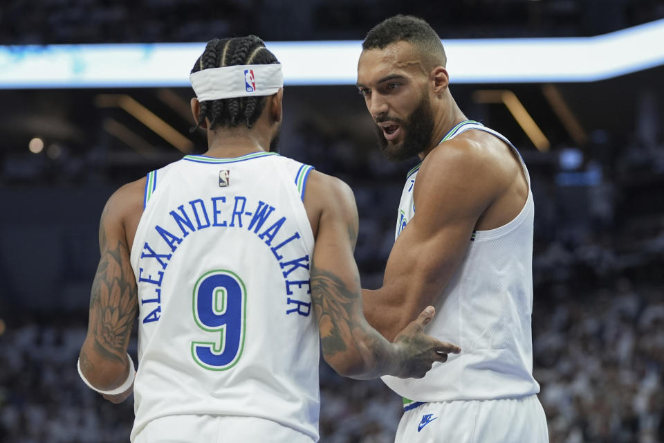 Minnesota Timberwolves guard Nickeil Alexander-Walker (9) and Rudy Gobert talk during the first half of Game 1 of an NBA basketball first-round playoff series against the Phoenix Suns, Saturday, April 20, 2024, in Minneapolis. (AP Photo/Abbie Parr)