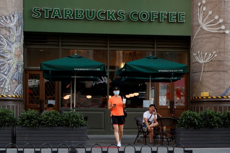 FILE PHOTO: A woman leaves a cafe of Starbucks Coffee in Beijing