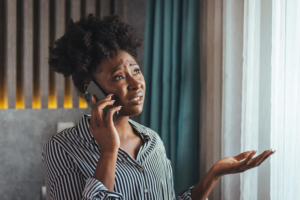 a concerned woman while she talks on the phone