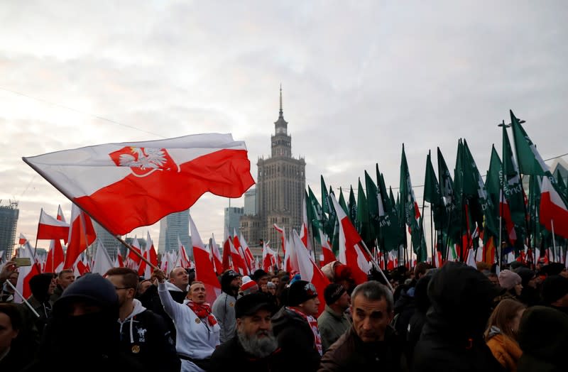 People hold flags during a march marking the 101st anniversary of Polish independence in Warsaw