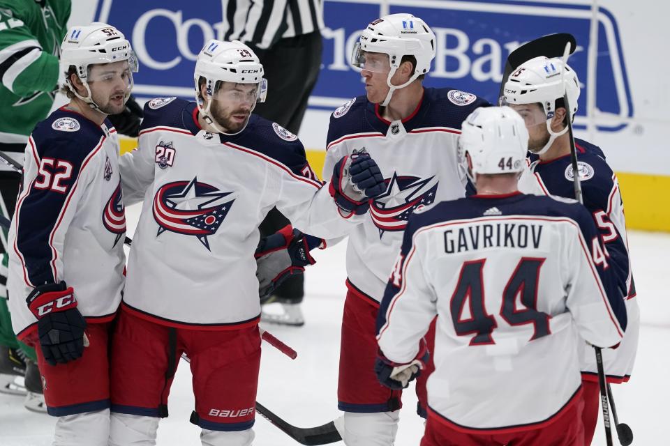 Columbus Blue Jackets' Emil Bemstrom (52), Oliver Bjorkstrand (28), Riley Nash (20), Vladislav Gavrikov (44) and Michael Del Zotto, right, celebrate a goal by Bjorkstrand during the third period of an NHL hockey game against the Dallas Stars in Dallas, Thursday, March 4, 2021. (AP Photo/Tony Gutierrez)