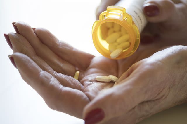 <p>Tetra Images / Getty Images</p> Female pouring medication into her palm.