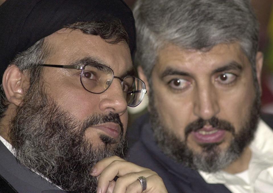 FILE - Sheik Hassan Nasrallah, leader of Hezbollah, left, chats with Khaled Mashaal, in south of Beirut, Lebanon, March 27, 2004. The gas-rich nation of Qatar has become a key intermediary over the fate of some 200 hostages held by Hamas after their unprecedented attack on Israel, once again putting the small Arabian Peninsula in the spotlight. (AP Photo/Hassan Ammar, File)