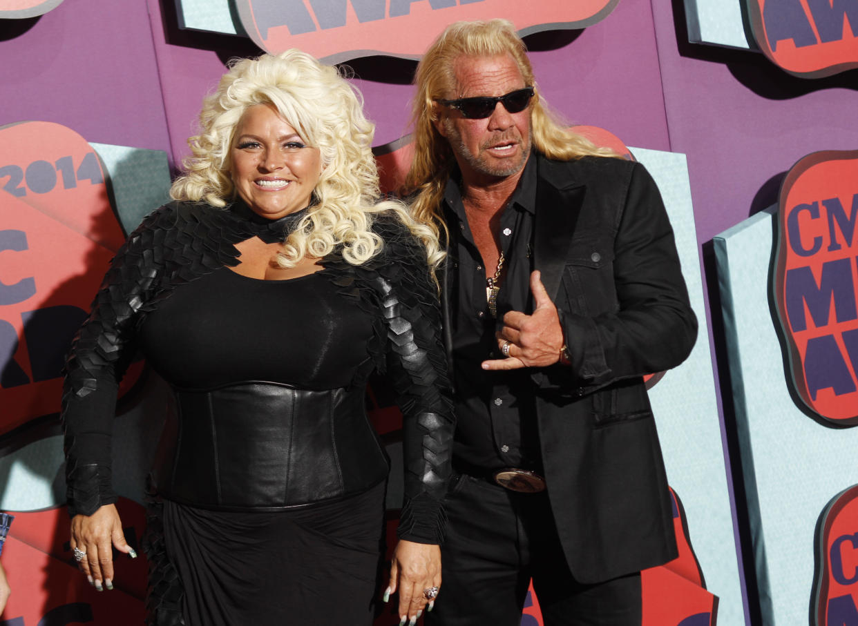 FILE - In this June 4, 2014 file photo, Beth Chapman, left, and Duane Chapman arrive at the CMT Music Awards at Bridgestone Arena, in Nashville, Tenn. Hawaii's attorney general says "Dog the Bounty Hunter" reality TV star Duane "Dog" Chapman's bail bonds business owes the state $35,000. Attorney General Doug Chin says Wednesday, July 13, 2016, his office is suing Da Kine Bail Bonds for money it promised to pay when the company's clients skipped court. (Photo by Wade Payne/Invision/AP, File)