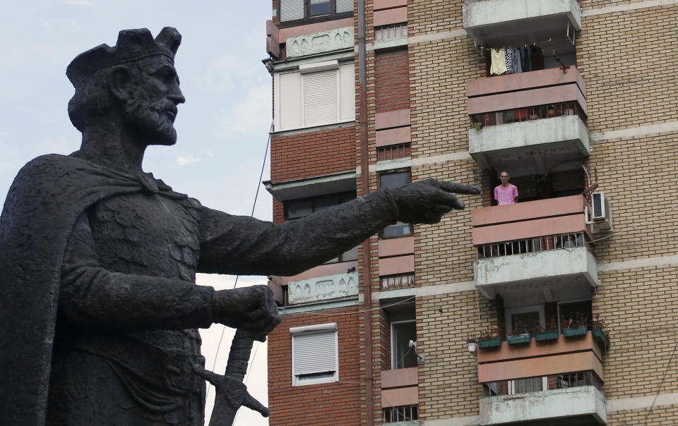 A man standing on a balcony looks towards the monument of the late Serbian Duke Lazar who was killed inthe Battle of Kosovo in June 1389, in the northern, Serb-dominated part of Mitrovica, Kosovo, Friday, Sept. 7, 2018. The idea of ​​a "land swap" between Serbia and Kosovo to resolve their long-running dispute once and for all has stirred passions ahead of a new round of talks between former war foes. (AP Photo/Darko Vojinovic)