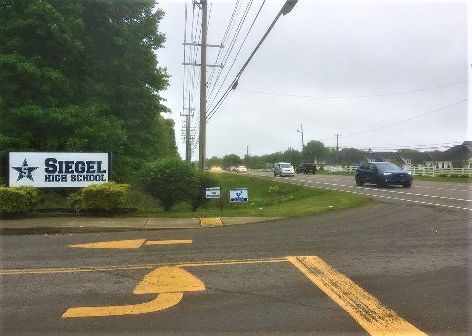 Commuters on Thompson Lane pass a sign for a Siegel High entrance May 5, 2021. The school and adjacent Siegel Middle will give up nearly a half acre by Thompson Lane after the Rutherford County Board of Education agreed to sell this land as right of way to the Tennessee Department of Transportation for a future road widening project that possibly could be completed in about five years.