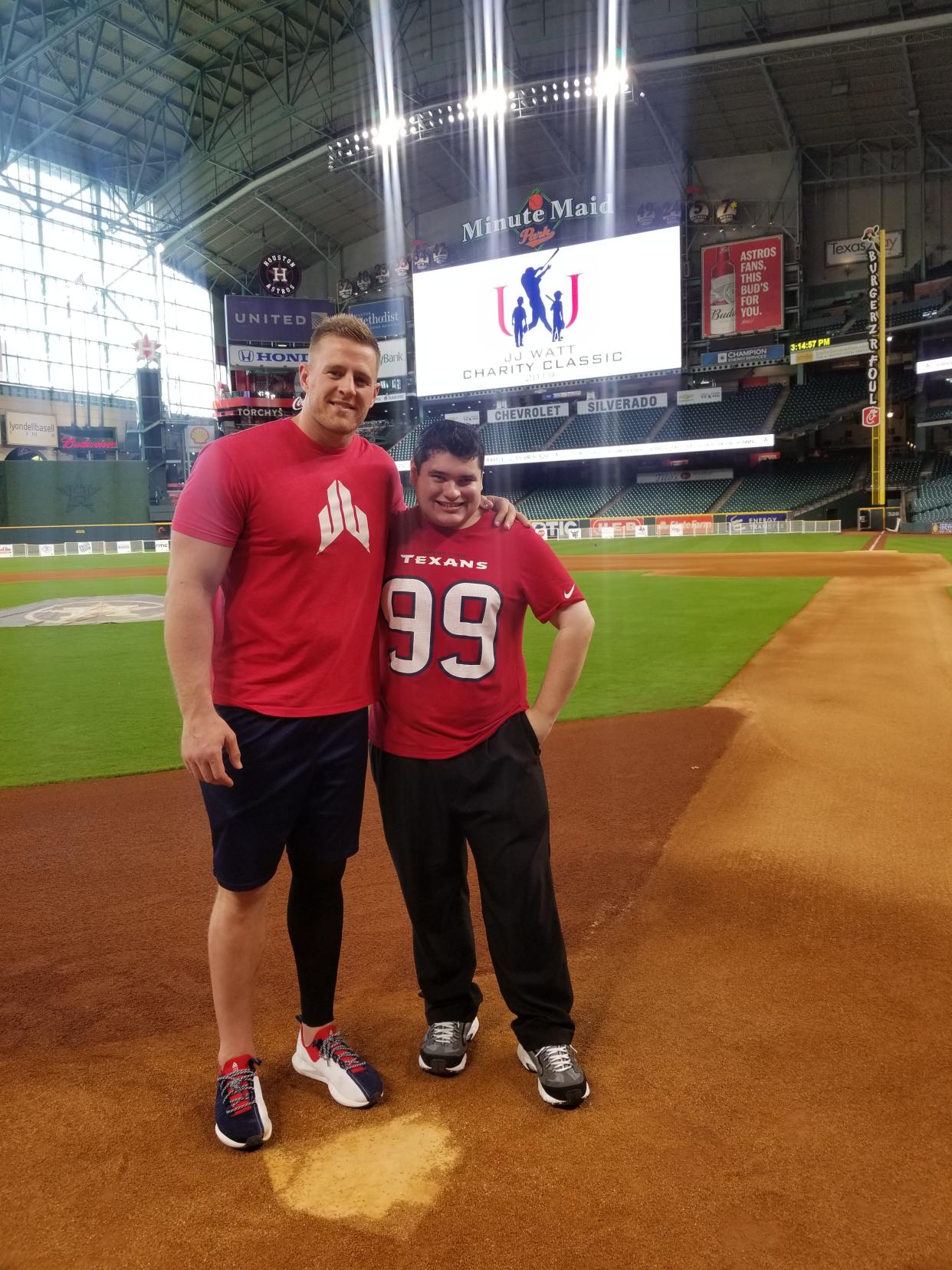 J.J. Watt poses with artist Grant Manier at a JJ Watt Foundation baseball game. Manier made a portrait of the NFL star for a charity fundraiser.