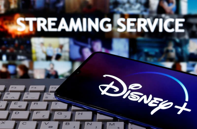 FILE PHOTO: Smartphone with displayed "Disney" logo is seen on the keyboard in front of displayed "Streaming service" words in this illustration