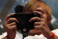 A visitor plays a Playstation PS Vita during the Gamescom 2012 fair in Cologne August 16, 2012.