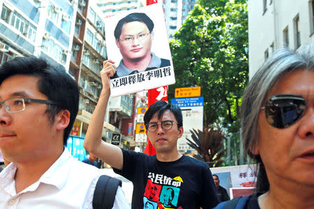 Pro-democracy protesters carry a photo of detained Taiwanese rights activist Lee Ming-Che during a demonstration in Hong Kong, China September 11, 2017. REUTERS/Bobby Yip