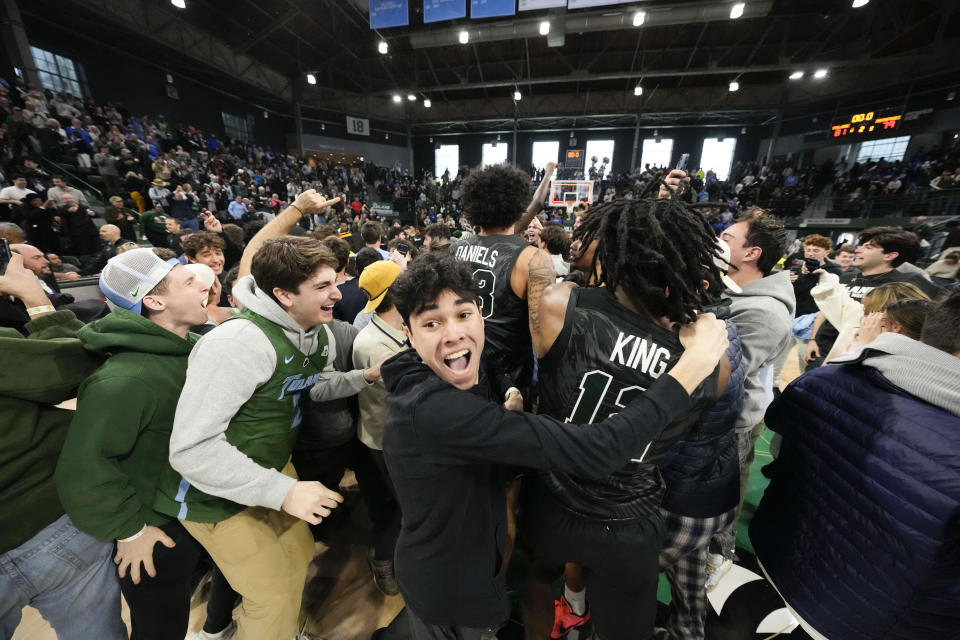 Fans storm the court as Tulane celebrates their victory over Memphis in an NCAA college basketball game in New Orleans, Sunday, Jan. 21, 2024. Tulane won 81-79. (AP Photo/Gerald Herbert)