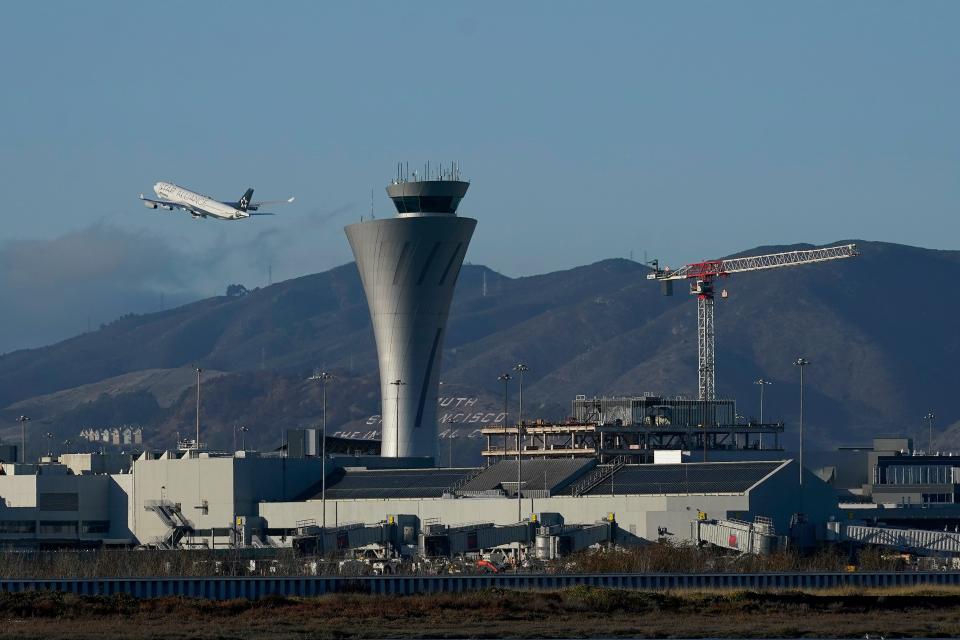 A plane takes off behind the air traffic control tower at San Francisco International Airport in San Francisco, Nov. 24, 2020.
(Credit: Jeff Chiu, AP)