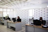 Employees of the State Independent Authority of Public Revenue speak to citizens via teleconference in Athens