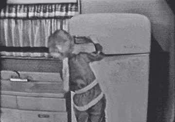 A boy pulls frozen food out of a freezer