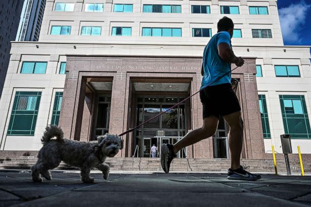 PHOTO: A man jogs with his dog outside the James Lawrence King Federal Justice Building on January 17, 2023 in Miami. (Chandan Khanna/AFP via Getty Images)