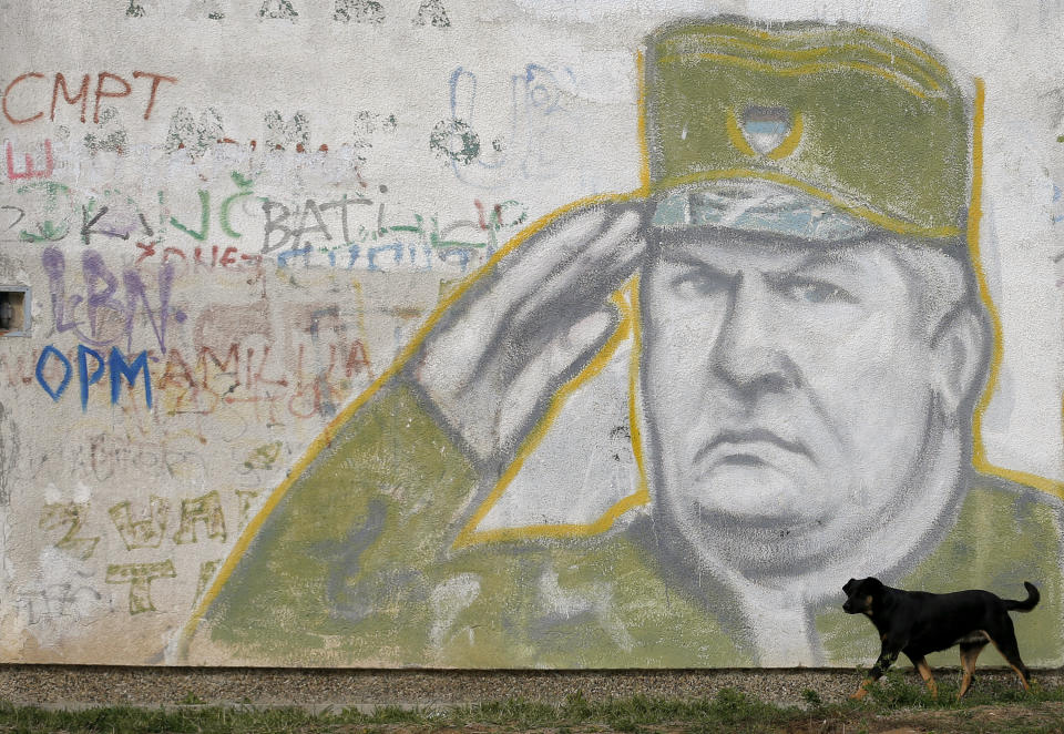 FILE — In this Tuesday, Nov. 7, 2017 file photo, a dog walks past a mural depicting former Bosnian Serb Gen. Ratko Mladic decorating a the wall of an apartment building in Belgrade, Serbia. U.N. judges on Tuesday, June 8, 2021 deliver their final ruling on the conviction of former Bosnian Serb army chief Radko Mladic on charges of genocide, war crimes and crimes against humanity during Bosnia’s 1992-95 ethnic carnage. Nearly three decades after the end of Europe’s worst conflict since World War II that killed more than 100,000 people, a U.N. court is set to close the case of the Bosnian War’s most notorious figure. (AP Photo/Darko Vojinovic, File)