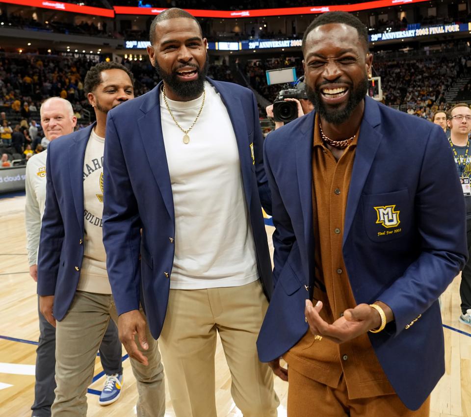 Former Marquette teammates Dwyane Wade and Robert Jackson share a moment after the halftime ceremony that honored the 2002-03 team that advanced to the Final Four.