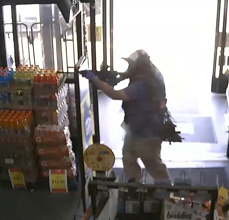 Ryan Christopher Palmeter is shown in a still image from surveillance video holding a rifle at a Dollar Store