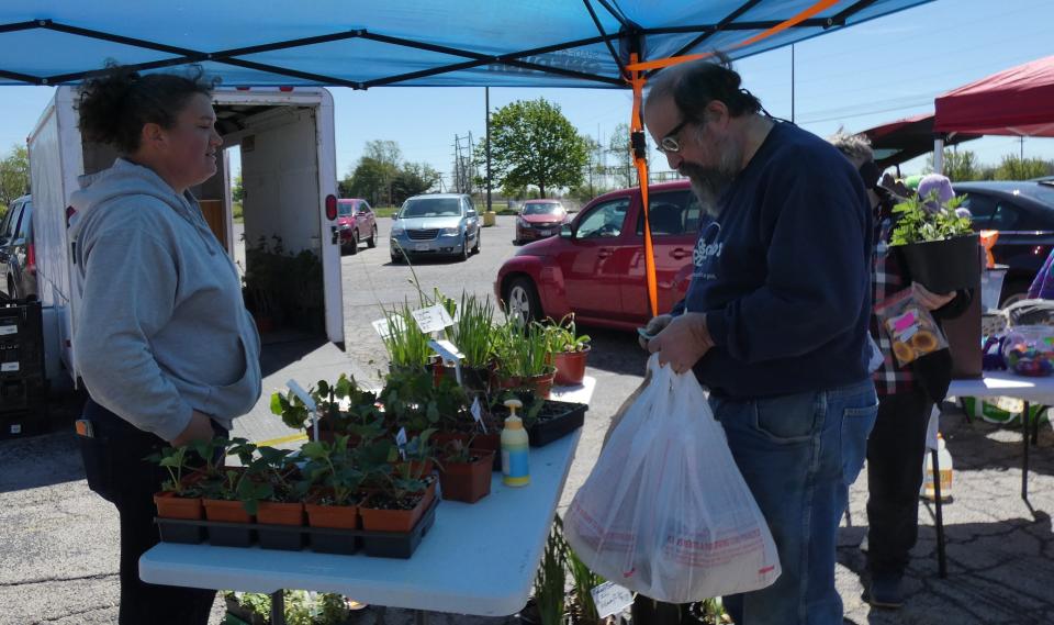 Melinda Hoffman, left, sells plants at a 2021 Bucyrus Farmers Market. “I just absolutely love playing with the plants and planting them up, and I can’t grow them all for myself,” Hoffman says, looking forward to being at the market this year when it opens in May. (TELEGRAPH-FORUM FILE PHOTO)