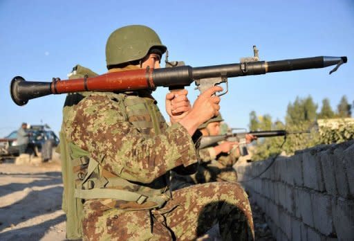 An Afghan National Army (ANA) soldier holds a rocket-propelled grenade launcher as he keeps watch near the scene of a suicide attack in Jalalabad on December 2. Taliban insurgents launched a major suicide attack against a NATO base at an Afghan city airport, killing five people and wounding several foreign troops, officials said