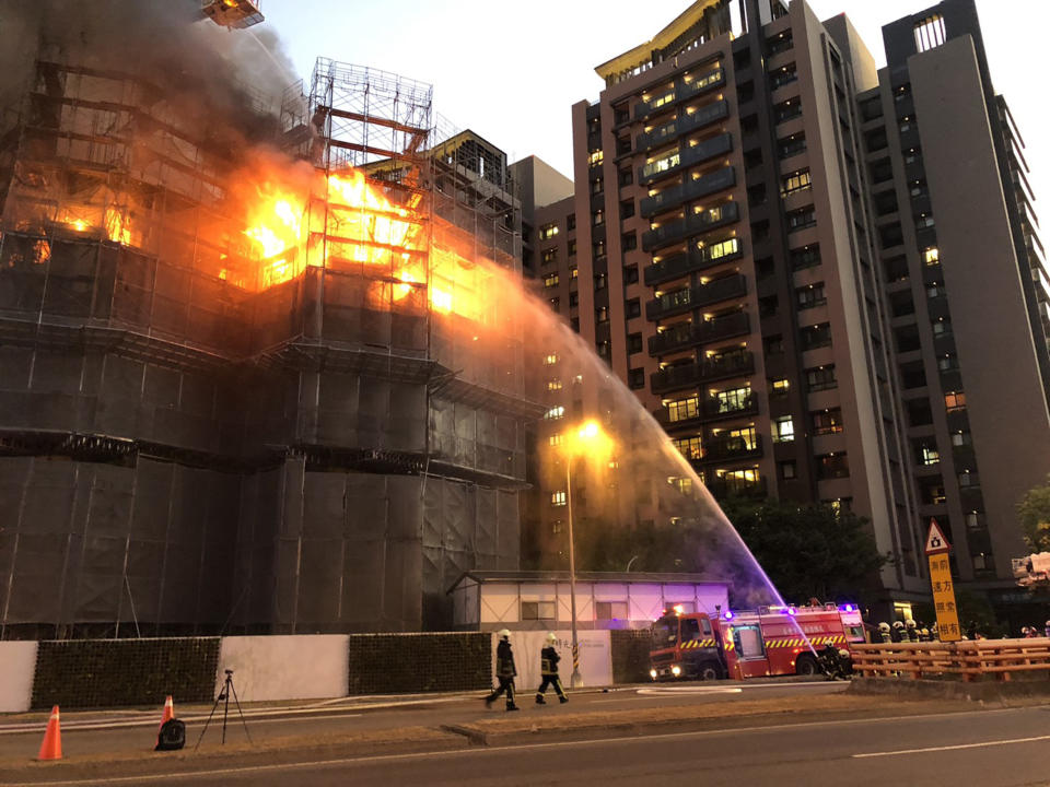 台中市南屯區一處興建中的大樓社區建案，今天晚間起火燃燒，消防局獲報到場搶救，因火勢猛烈，再加派雲梯車到場支援。（中央社）