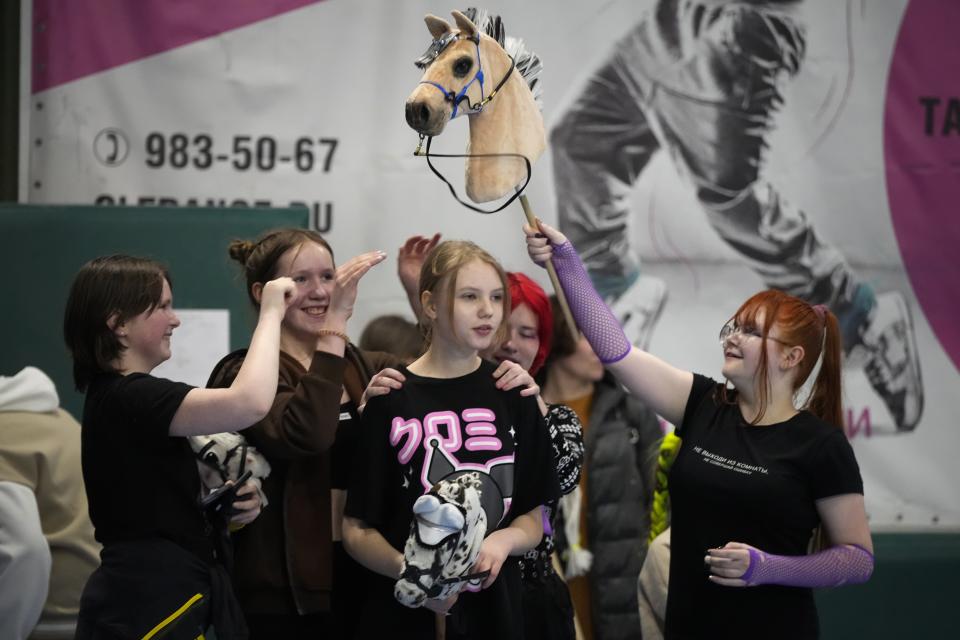 Girls wish good luck to their friend prior to her race during a Hobby horsing competition in St. Petersburg, Russia, on Sunday, April 21, 2024. Several dozen kids, 48 girls and one boy, from first-graders to teenagers gathered in a gymnasium in northern St. Petersburg, Russia's second largest city, for a hobby horsing competition. (AP Photo/Dmitri Lovetsky)