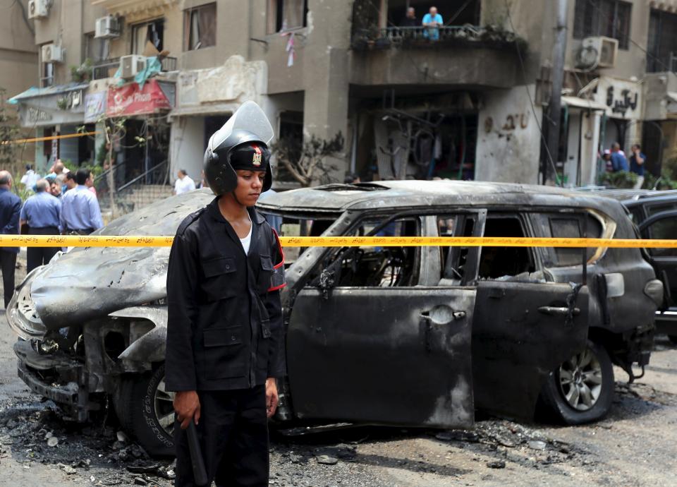 Policemen investigate the site of a car bomb attack on the convoy of Egyptian public prosecutor Hisham Barakat near his house at Heliopolis district in Cairo