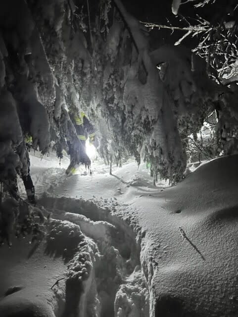 In this photo provided by Massachusetts State Police, a search team looks for two hikers stranded by heavy snow, on an overnight rescue operation, in Mount Washington State Forest in Massachusetts, early Wednesday, March 15, 2023. (Massachusetts State Police via AP)