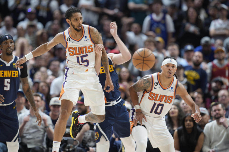 Phoenix Suns guard Cameron Payne, left, blocks a pass intended for Denver Nuggets guard Christian Braun, center, as Phoenix guard Damion Lee looks on in the second half of Game 2 of an NBA second-round playoff series Monday, May 1, 2023, in Denver. (AP Photo/David Zalubowski)