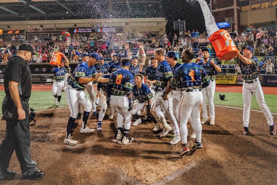 Victor Mesa Jr. (8) arrives at home plate with celebrating teammates and water dousing after his walkoff grand slam homer to beat Rocket City on July 22.