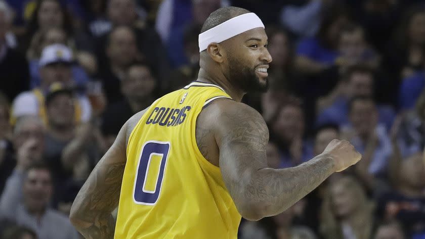 Golden State Warriors center DeMarcus Cousins smiles after scoring against the Denver Nuggets during an NBA basketball game in Oakland, Calif., Tuesday, April 2, 2019. (AP Photo/Jeff Chiu)